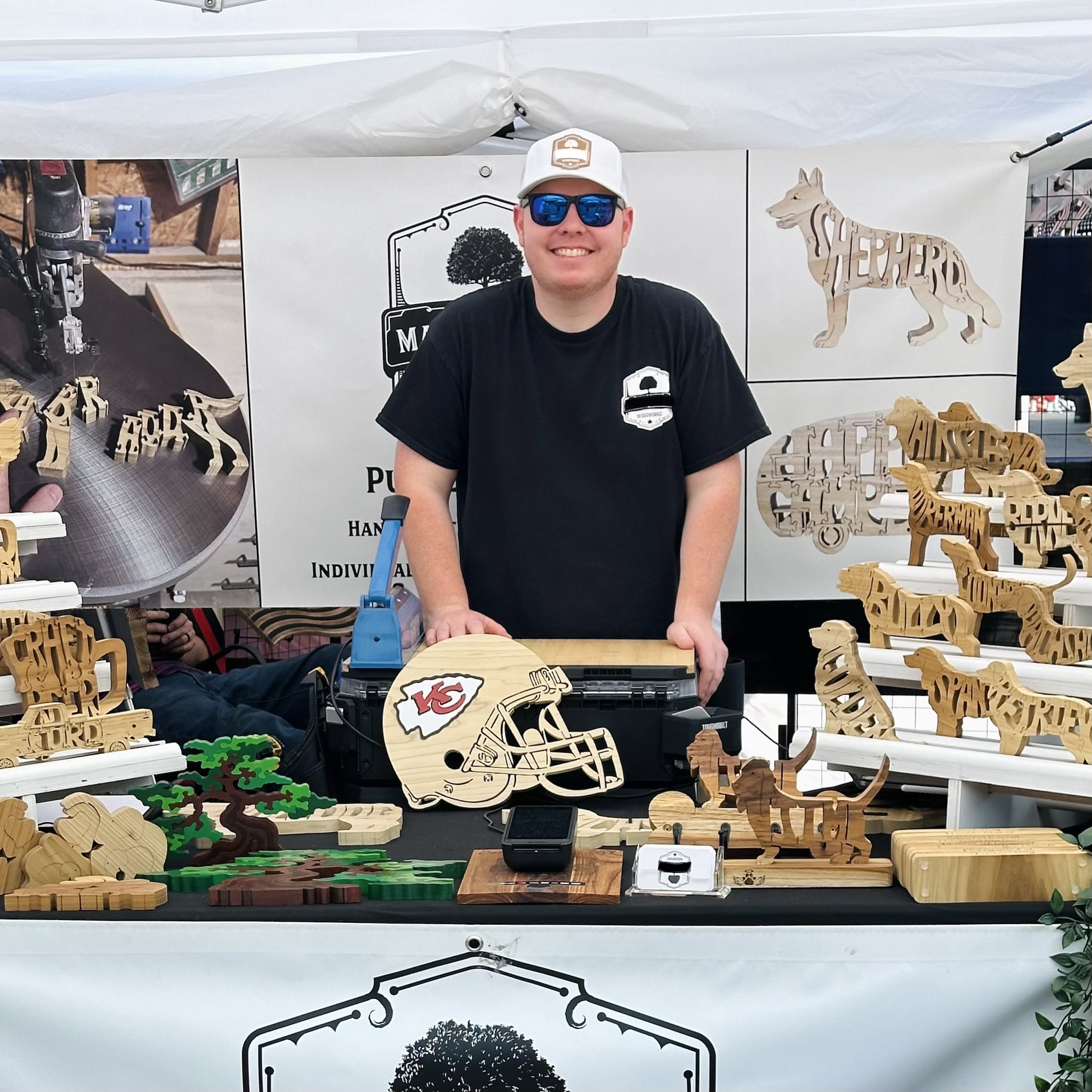 Ben McIntosh at a craft festival booth with handmade woodwork